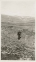 Image of Donald MacMillan walking on rough terrain